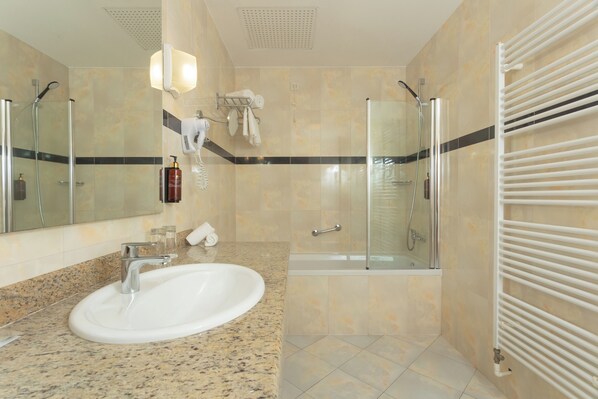 A modern bathroom with a large sink, a glass-enclosed shower, and a built-in towel rack. - Family Hotel La Luna (Novalja)