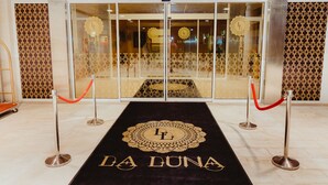 A hotel entrance with a black carpet featuring 'LA LUNA' and a red rope barrier. - Family Hotel La Luna (Novalja)