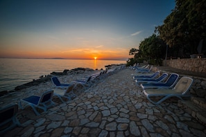 Nära stranden, solstolar, parasoller och strandhanddukar