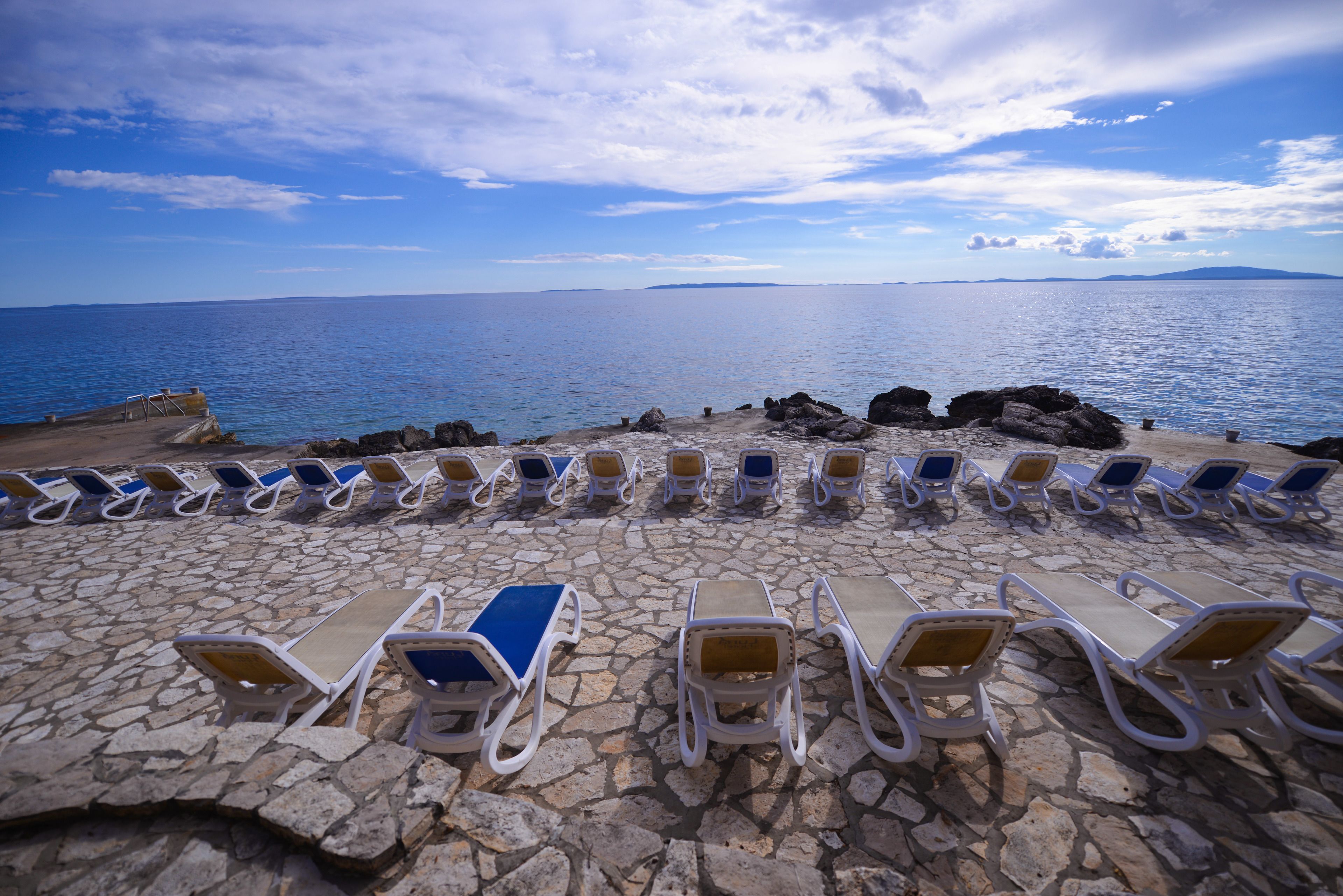 Vlak bij het strand, ligstoelen, parasols, strandlakens
