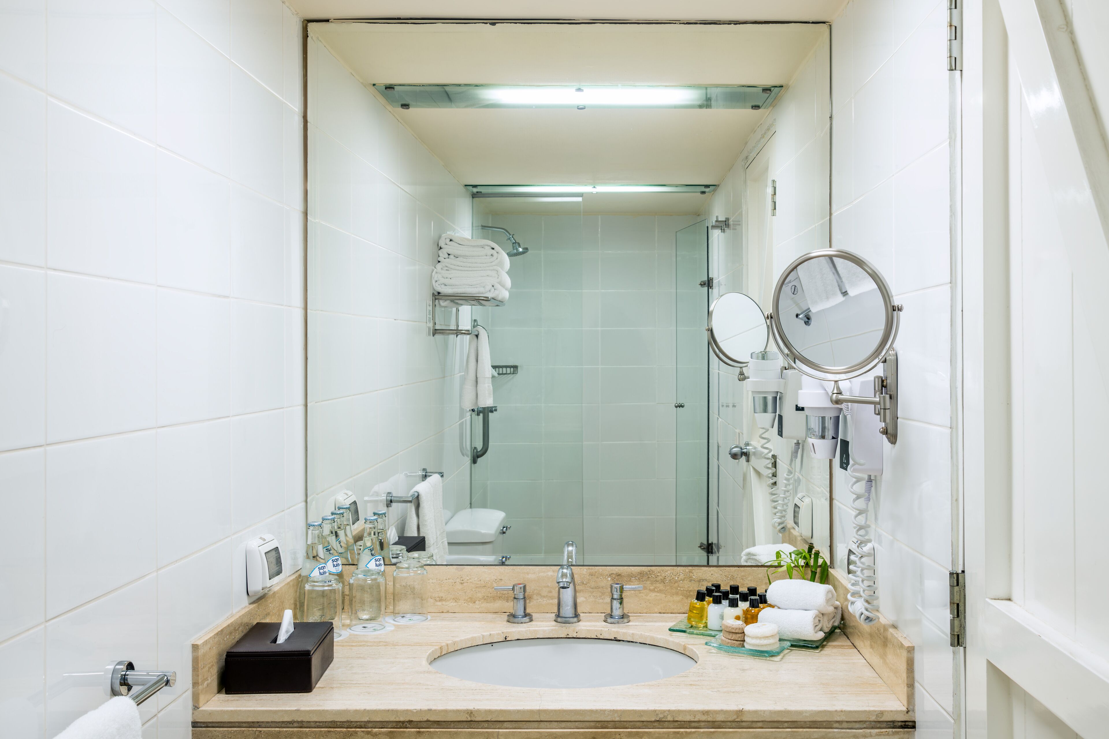 Un baño moderno con un espejo grande, un lavabo y una zona de ducha.