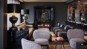 Una sala de estar moderna con chimenea, asientos cómodos y un ambiente luminoso.