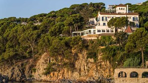 A coastal property with a large house surrounded by trees and cliffs. - Hotel Sant Roc (Palafrugell)