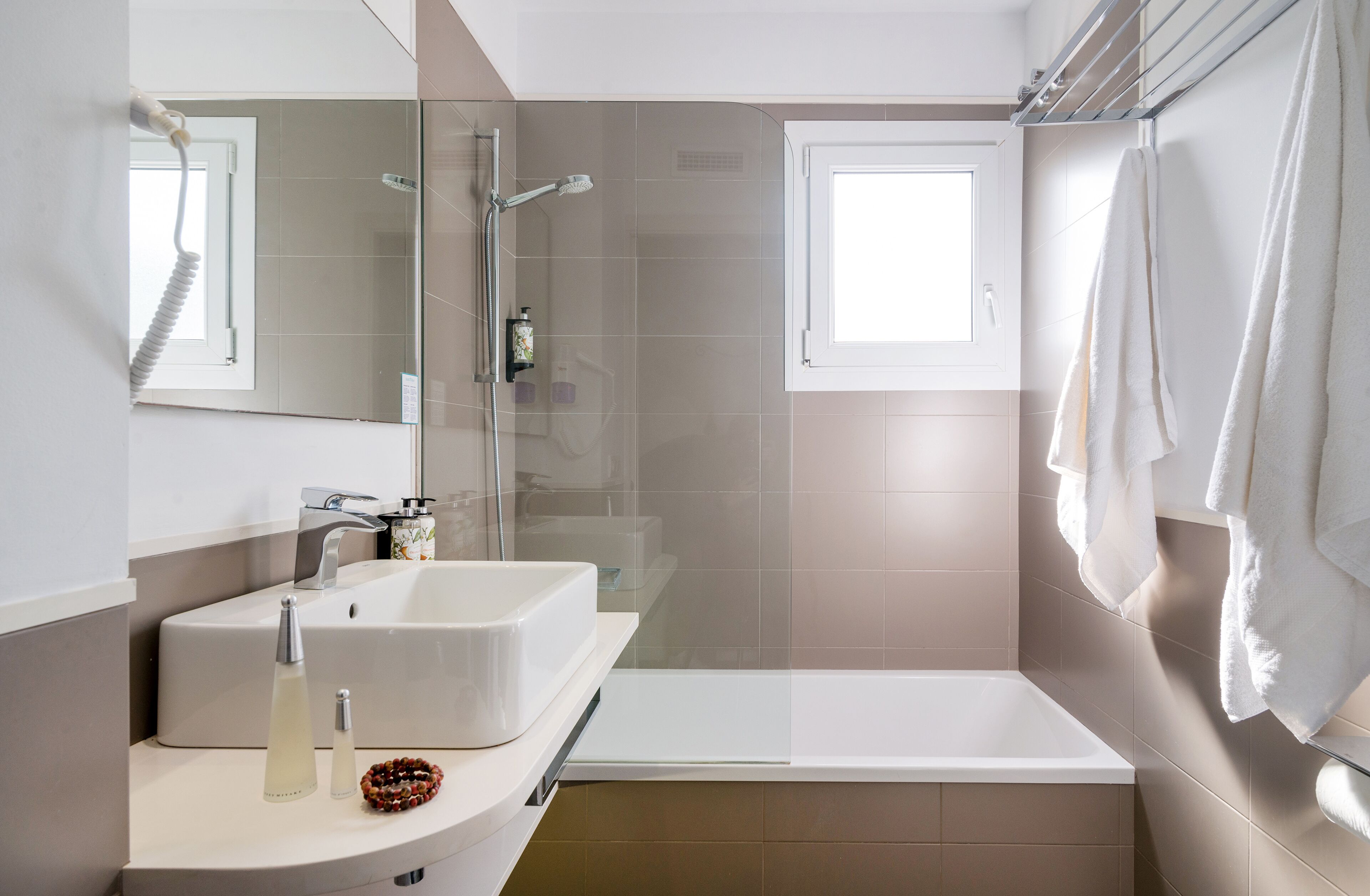 Un baño moderno con lavamanos blanco, cabina de ducha de vidrio y bañera.