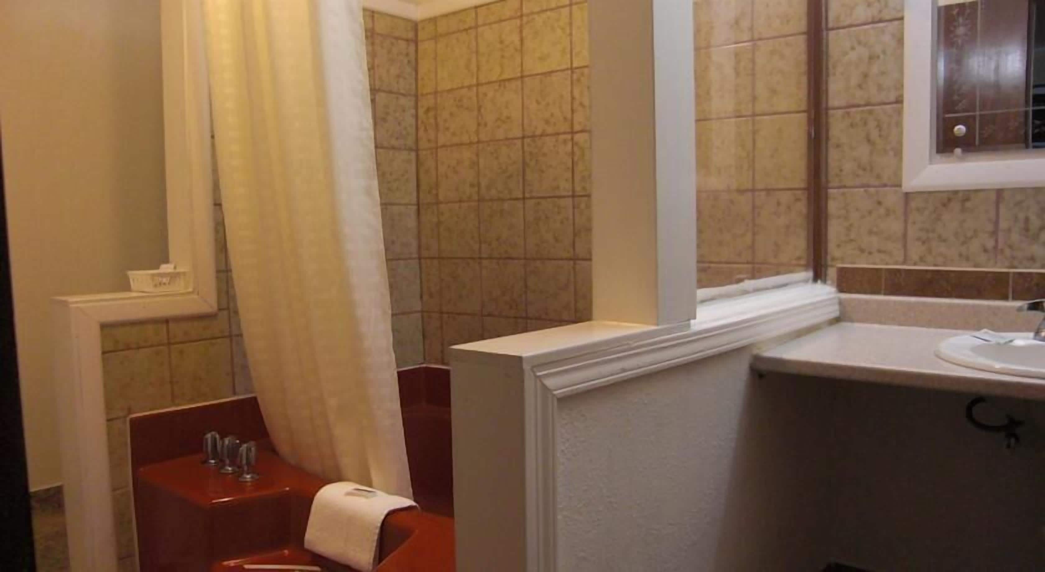 A bathroom with a shower, toilet, and sink.