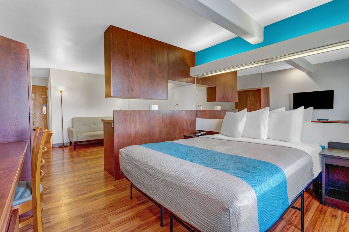 Escritorio, cortinas blackout y tabla de planchar con plancha