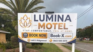 Ein Schild eines Motels mit einer Buchungsaufforderung und Kontaktinformationen.