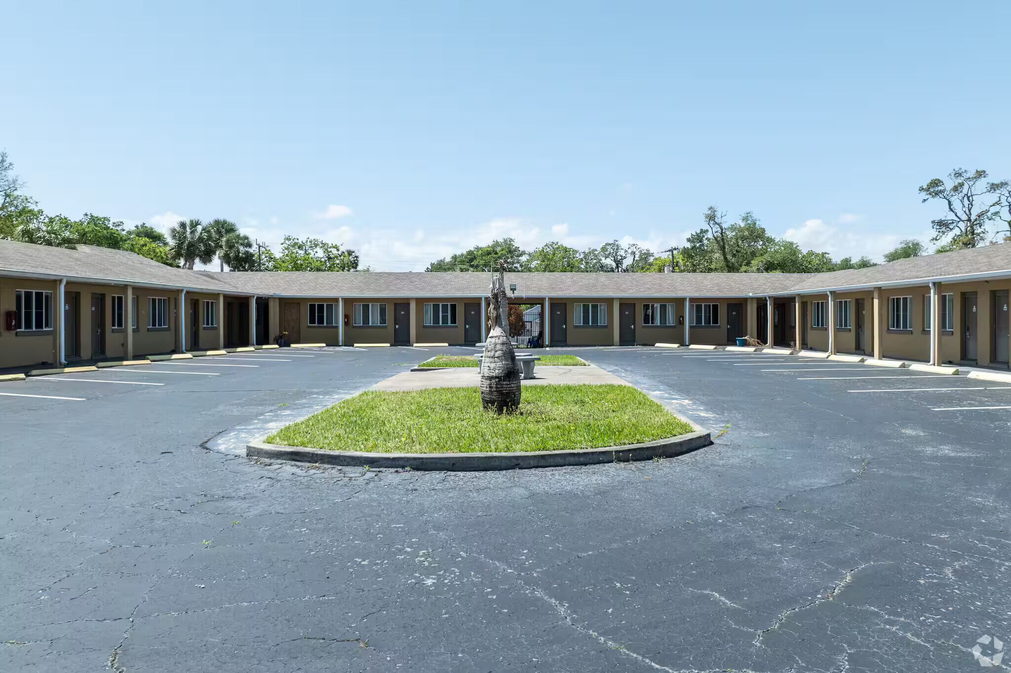 Un motel doté d  ’un espace vert central et de nombreuses chambres.