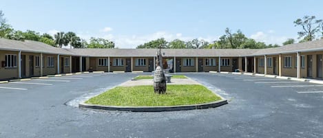A motel with a central grassy area and multiple rooms.