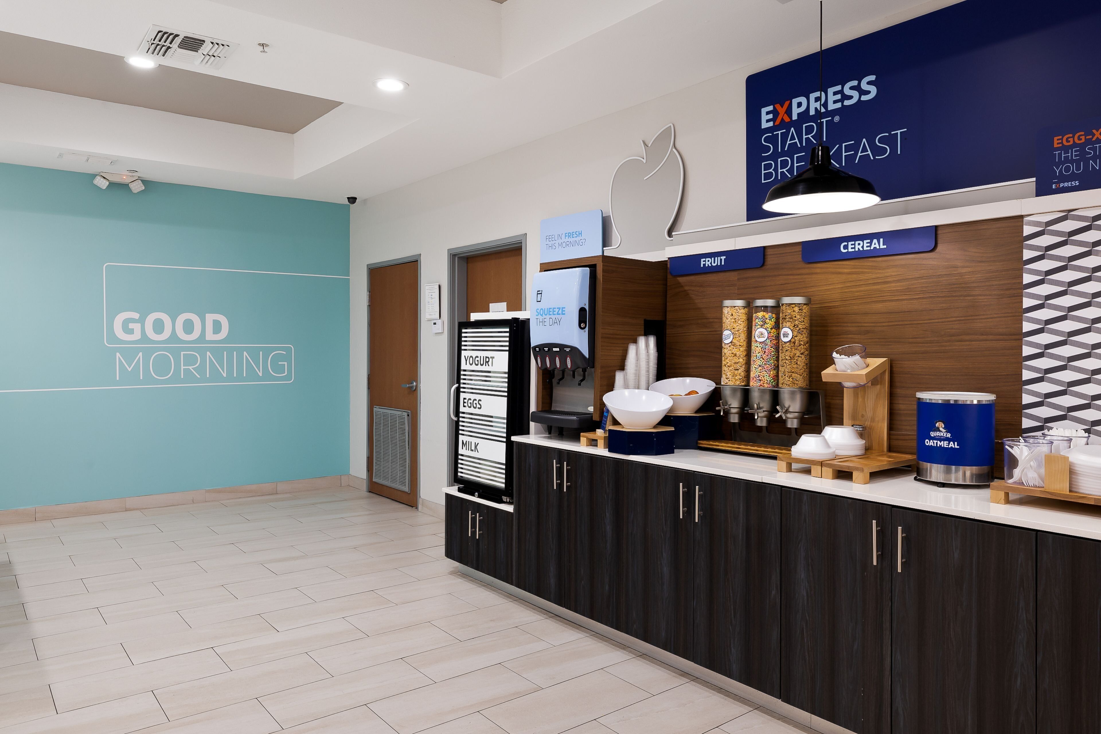 A modern breakfast area with a 'Good Morning' sign, yogurt, eggs, milk, cereal, and a coffee station.