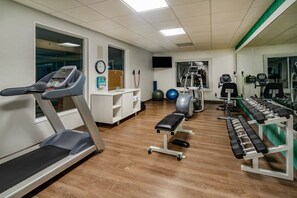 A gym with treadmills, a bench, and weight machines. - Holiday Inn Express Hotel & Suites Magee by IHG (Magee)