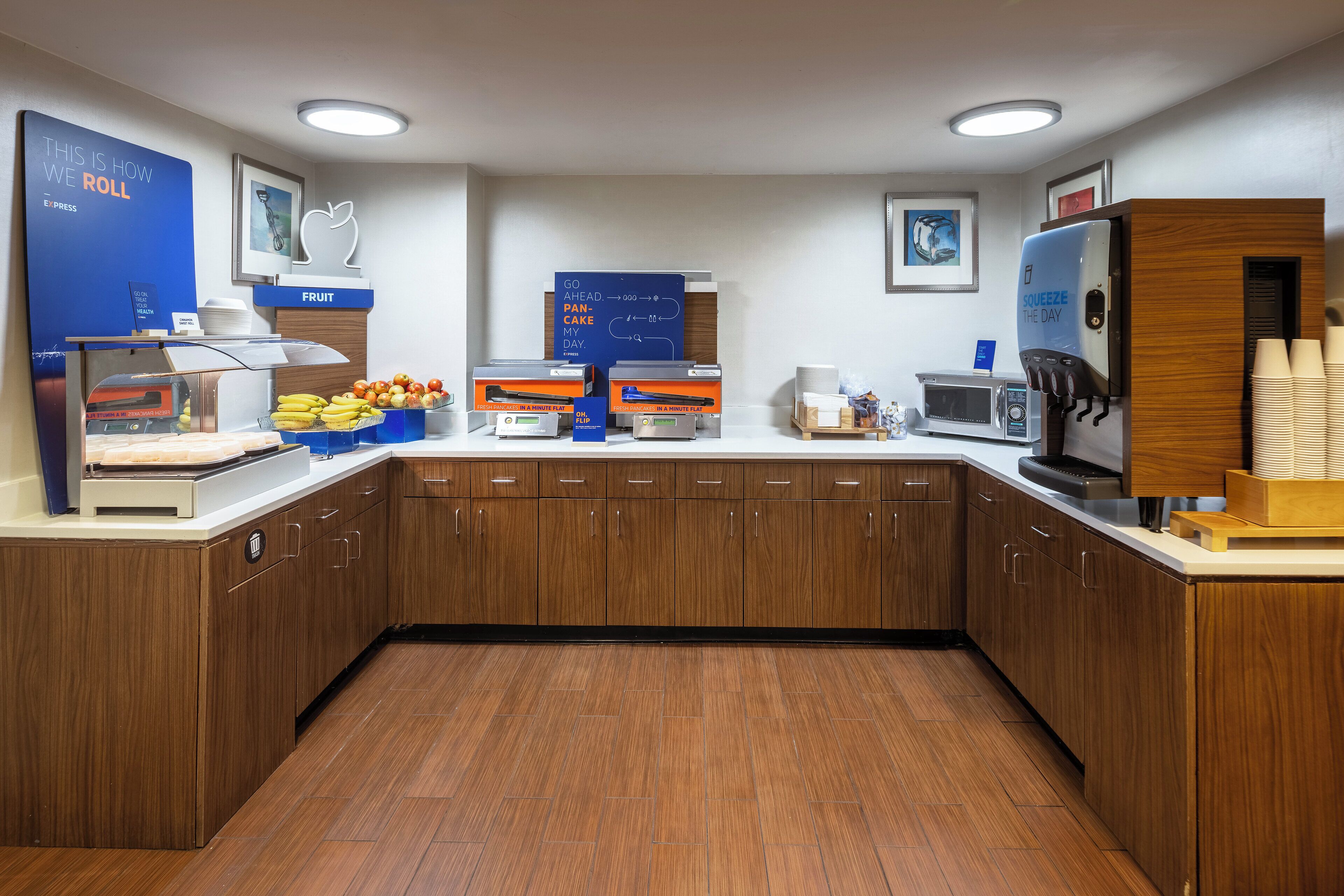 Una cucina moderna con mobili in legno, un espositore di frutta, una macchina per il caffè e un forno a microonde.