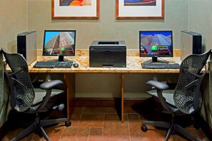 A workspace with two desktop computers, two printers, two keyboards, two mice, and two office chairs. - Holiday Inn Express New York City Times Square by IHG (New York)