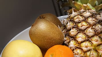 Un tazón con piña, kiwi, manzana y naranja.
