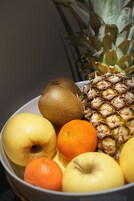 Una ciotola con ananas, kiwi, mela e arancia.