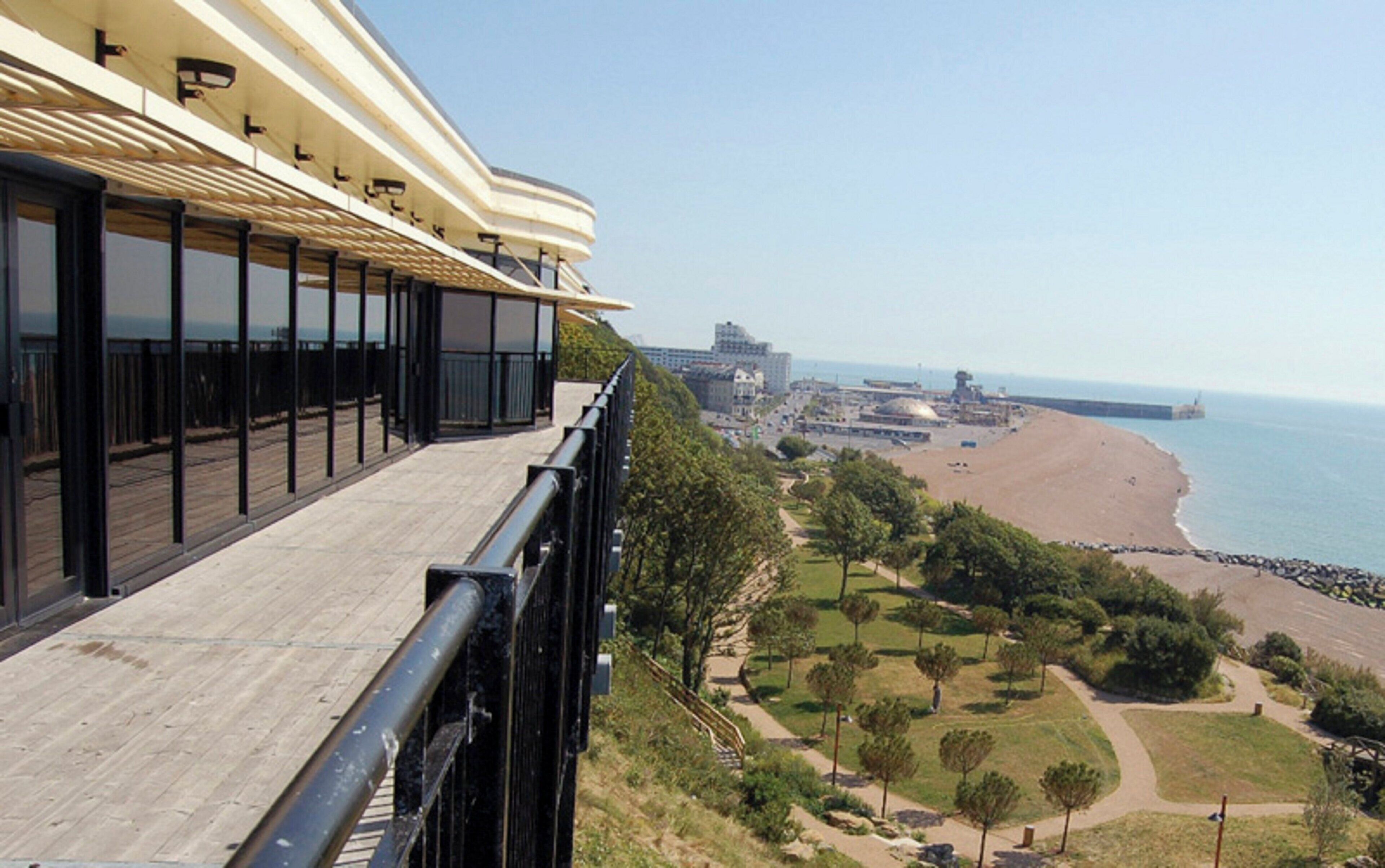 A balcony with a view of a beach and cityscape.