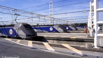 Estação de trem do Euro Túnel com vários trens estacionados na plataforma.