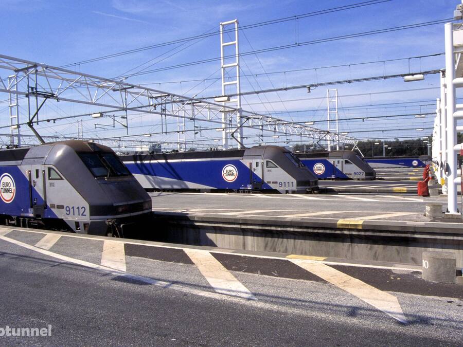 Estação de trem do Euro Túnel com vários trens estacionados na plataforma.