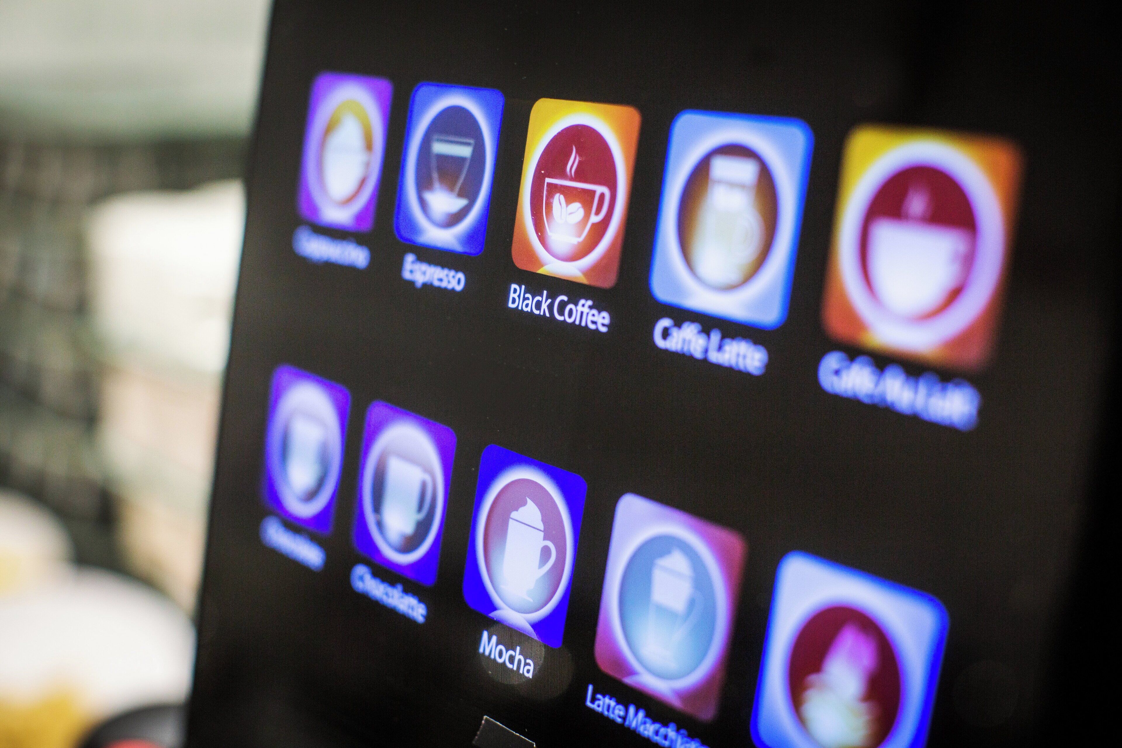 Un écran affiche une application pour un café, avec différentes options de boissons au café.