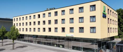 Un moderno edificio de hotel con fachada plana, múltiples ventanas y el letrero de Holiday Inn Express.