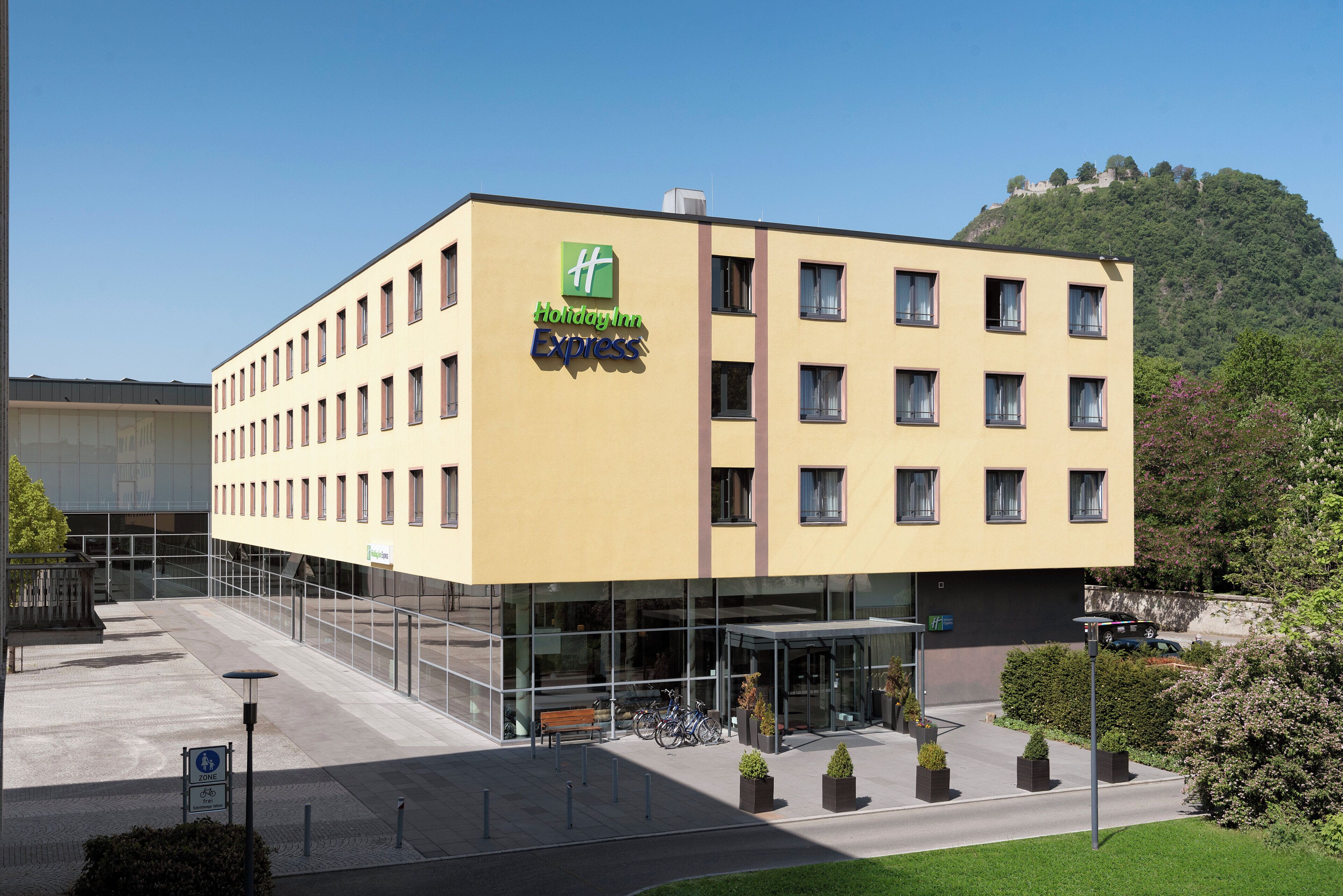 A Holiday Inn Express hotel with a modern facade, multiple windows, and a parking area with bicycles.