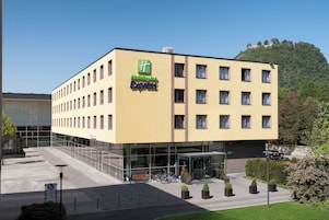 Un hotel Holiday Inn Express con una fachada moderna, varias ventanas y un estacionamiento con bicicletas.