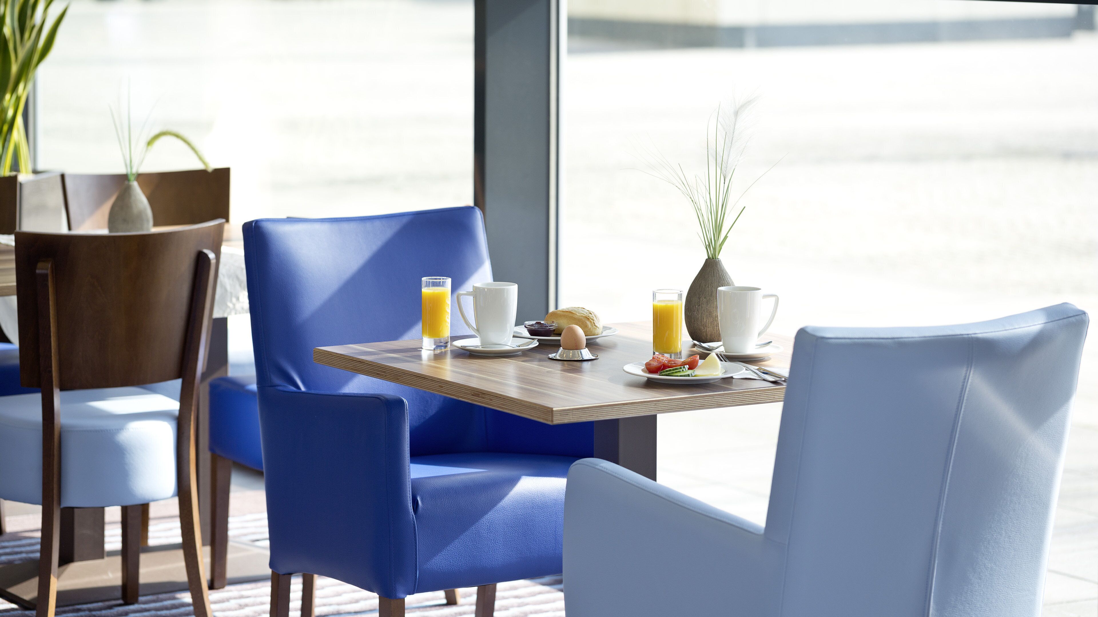 A breakfast setting with a table, chairs, and a view of the street.