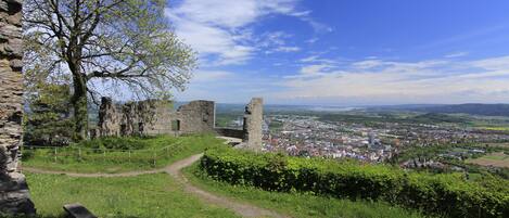 A historic stone structure with a path leading to a view of a modern cityscape.