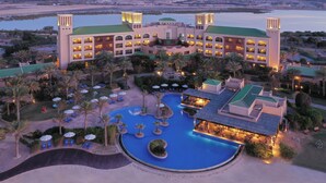 Un resort con varias construcciones, una gran piscina y una zona de playa.