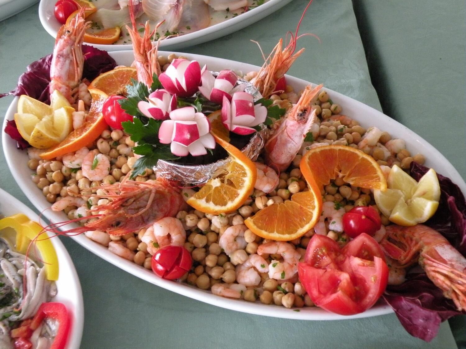 A seafood platter with shrimp, chickpeas, and vegetables.