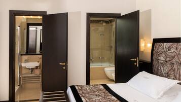 Une chambre d’hôtel avec un lit, une salle de bain avec une douche et un lavabo.