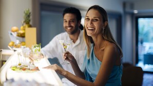 A dining table with a salad and a martini glass.
