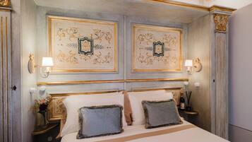 Een hotelkamer met een groot bed, twee nachtkastjes, decoratieve wandpanelen en wandlampen.