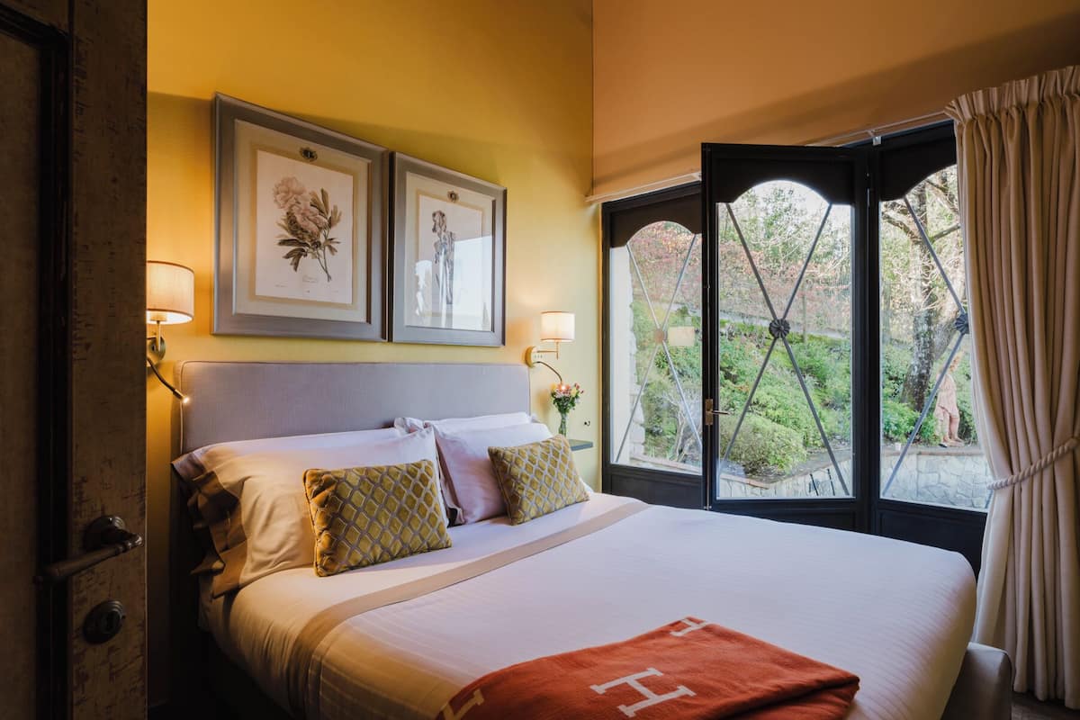 Deluxe Room, 1 Bedroom, Garden View | Minibar, in-room safe, desk, iron/ironing board