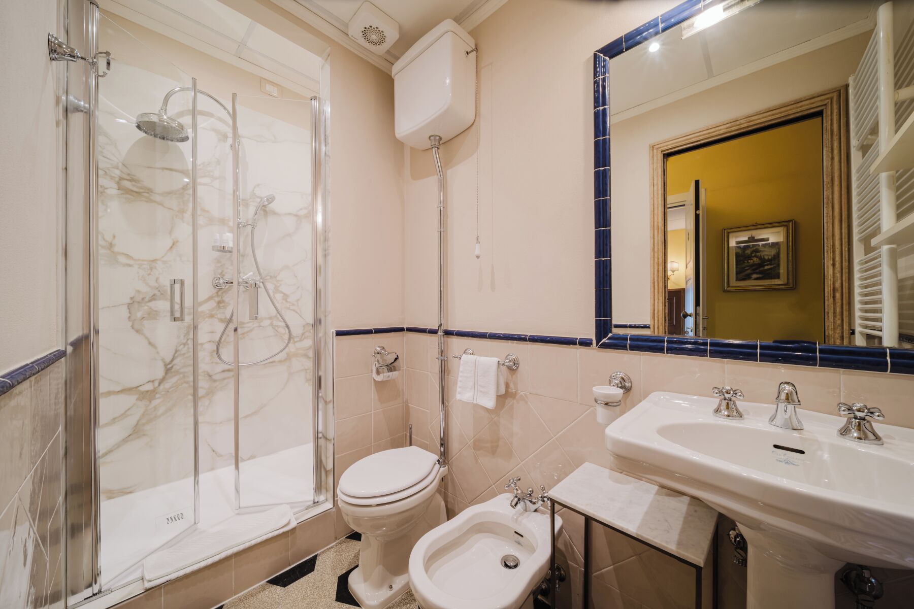 Un baño con ducha de vidrio, inodoro, bidé y lavamanos.
