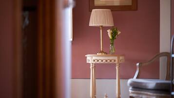 A room with a table, a lamp, and a chair.