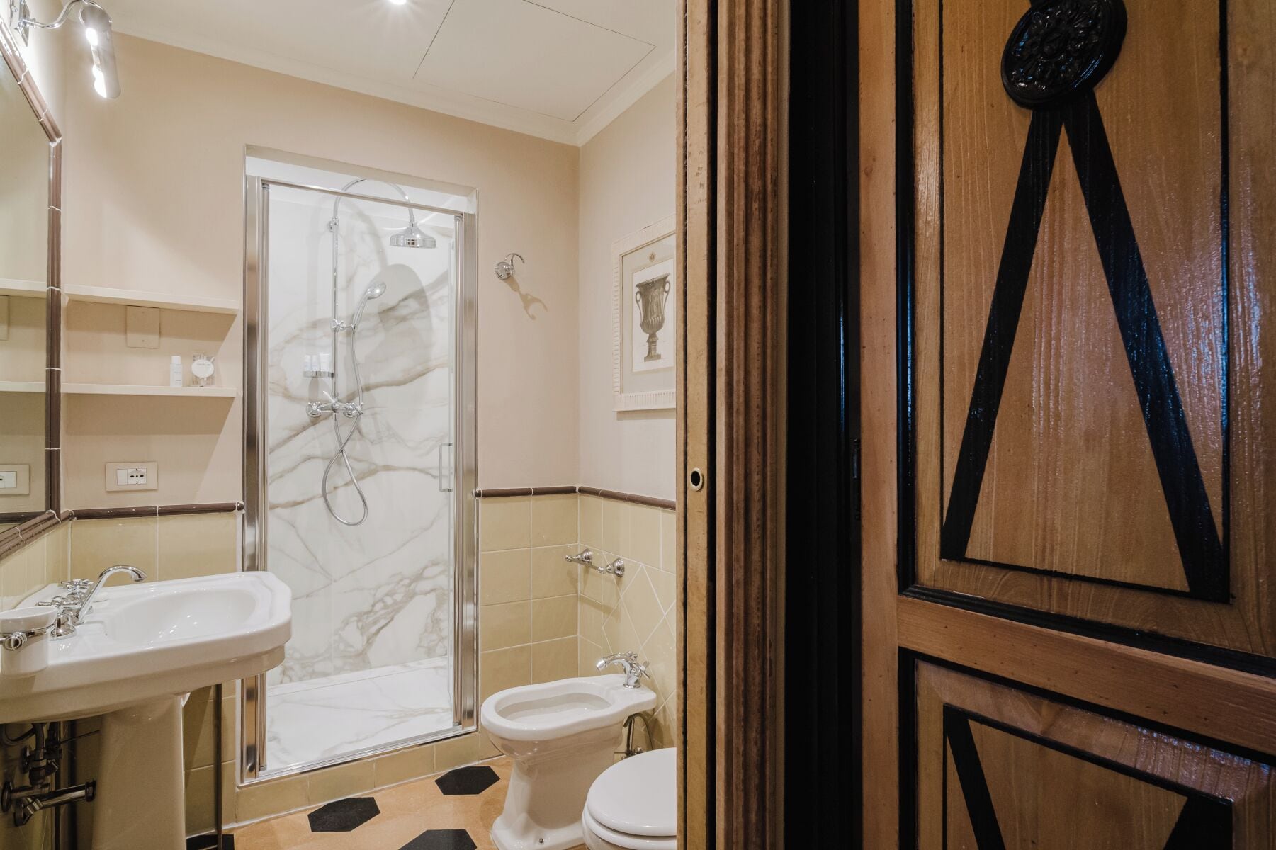 Ein Badezimmer mit Glasdusche, zwei Waschbecken, einer Toilette und einem Spiegel.