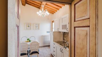 A kitchen with wooden cabinets, a white countertop, a sink, and a chandelier.