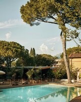 Una piscina al aire libre de temporada, sombrillas