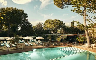 Una piscina al aire libre de temporada, sombrillas