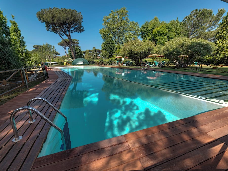 Una piscina al aire libre de temporada, sombrillas, tumbonas