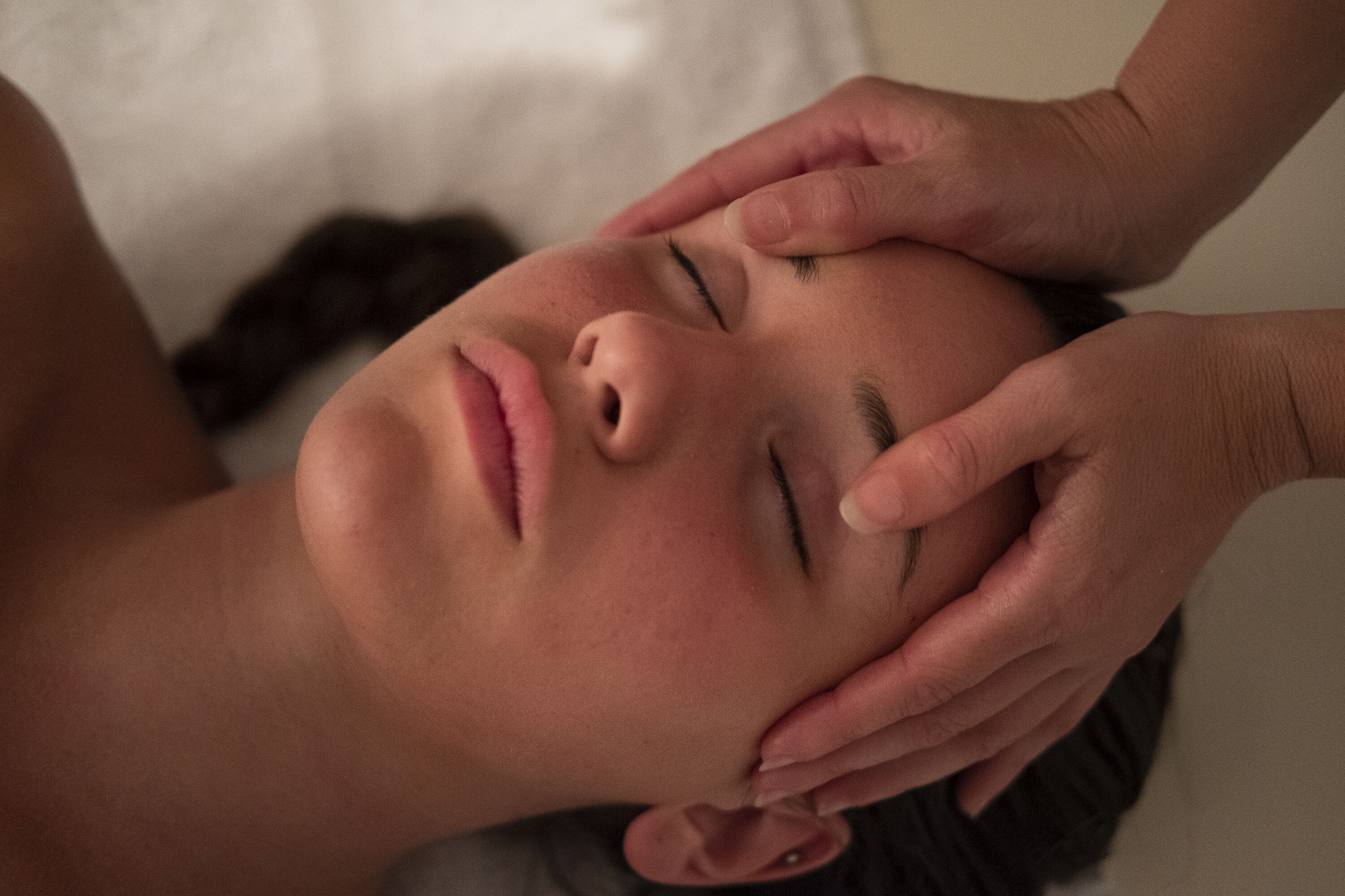 Une personne allongée, la tête reposant sur un oreiller.