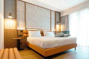 A modern hotel room with a large bed, a small table, and a bench. - Picciolo Etna Golf Resort & Spa, Curio Collection by Hilton (Castiglione di Sicilia)