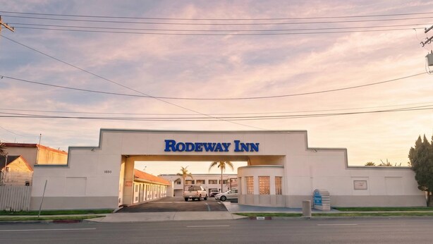 The entrance to a Rodeway Inn with a clear sky and a parking lot in front. - Rodeway Inn Ventura Midtown (Ventura)