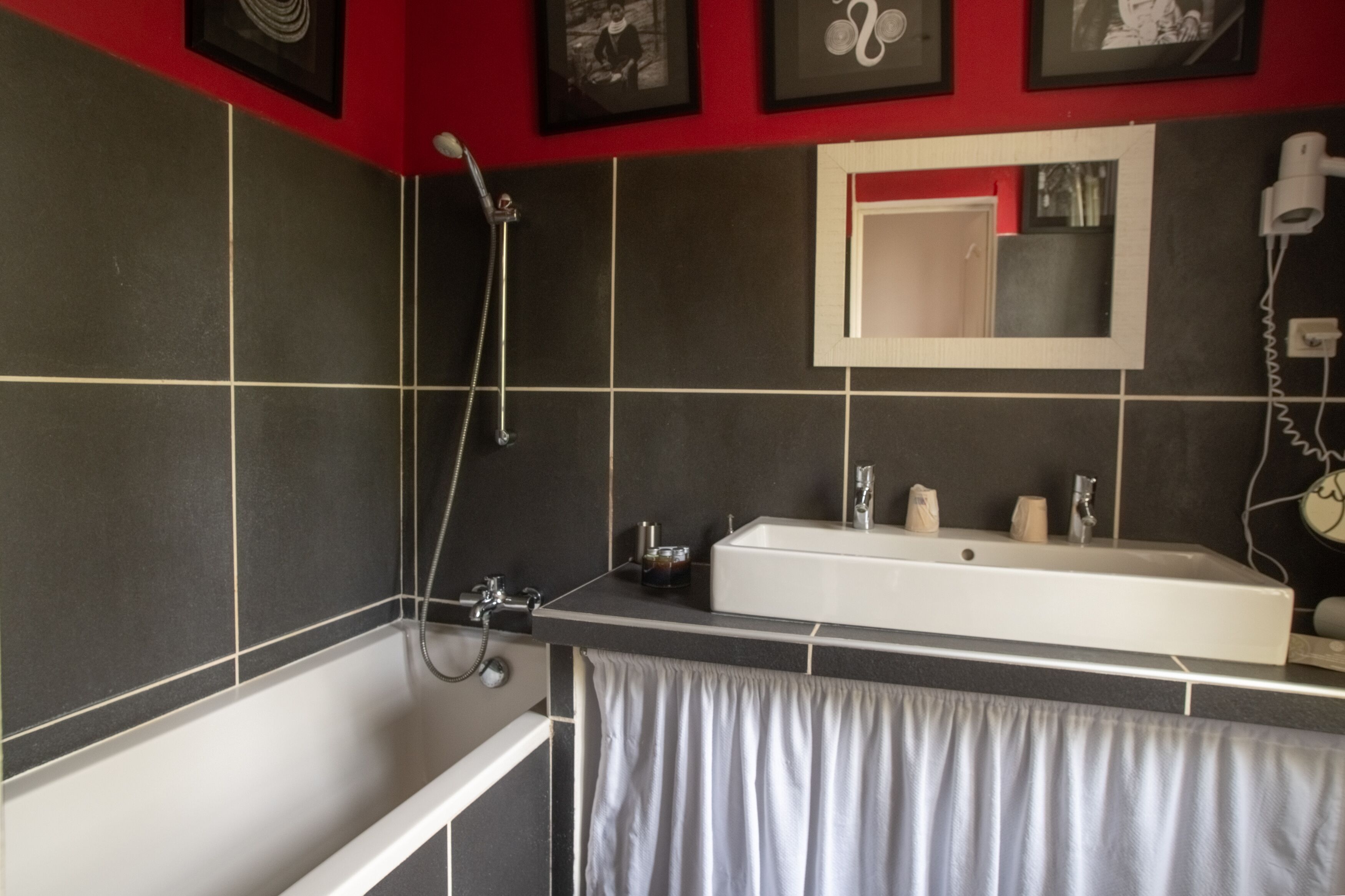 A modern bathroom with a bathtub, a large mirror, and a shower.
