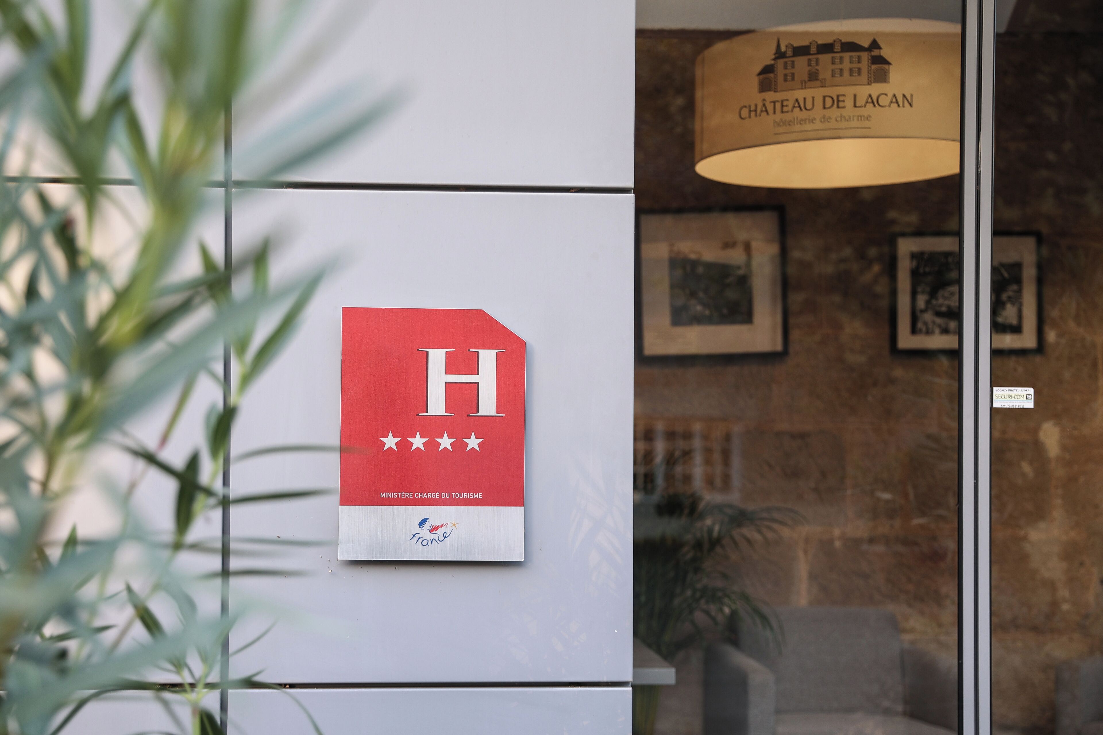 A hotel sign with a red background and a white 'H' with five stars, indicating a high rating.