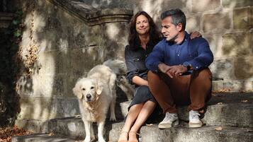 Un couple est assis sur des marches en pierre, avec un chien.