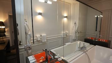 Un baño moderno con un espejo grande, una bañera y un lavamanos con lavabo.