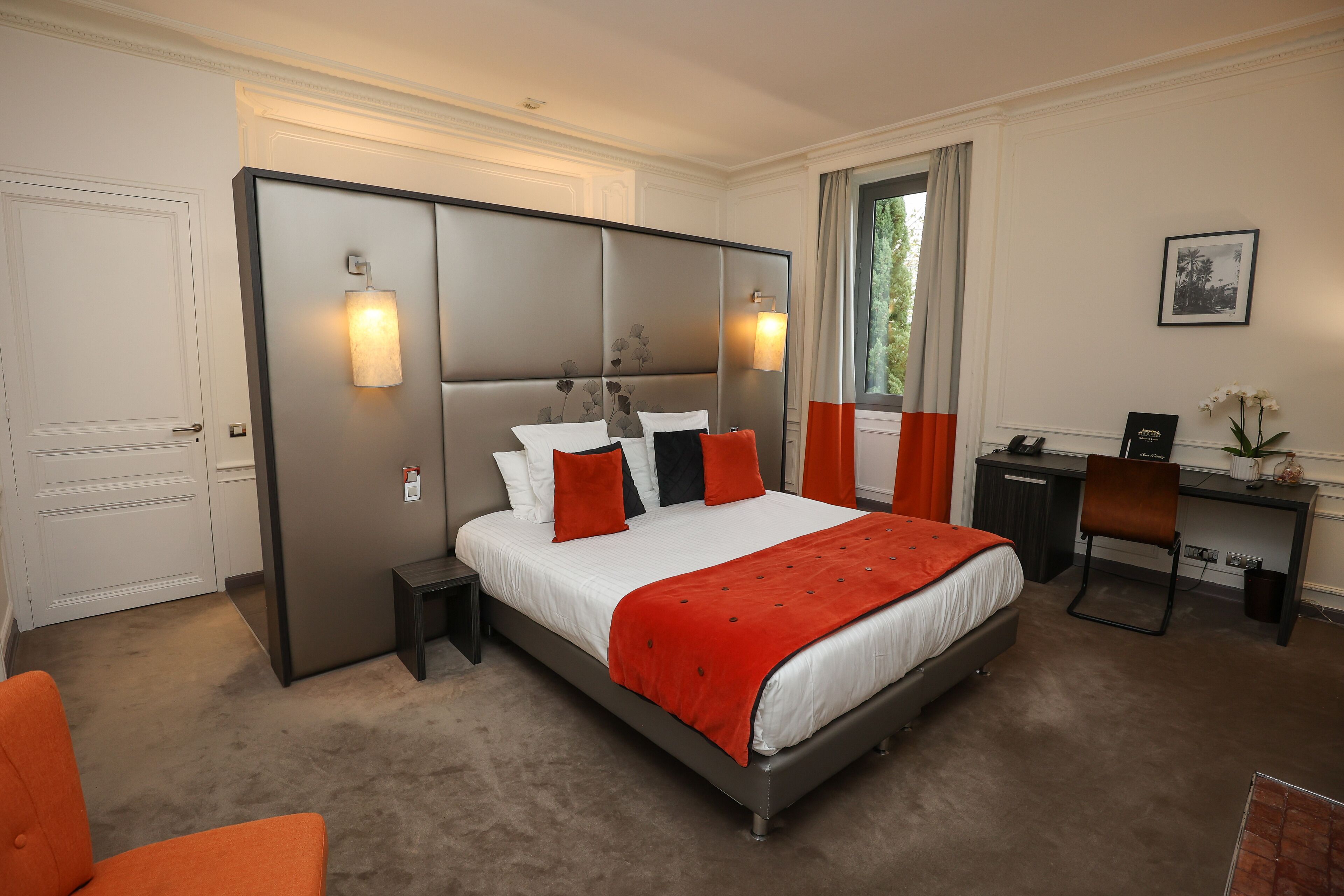 A modern bedroom with a large bed, a desk, and a chair.
