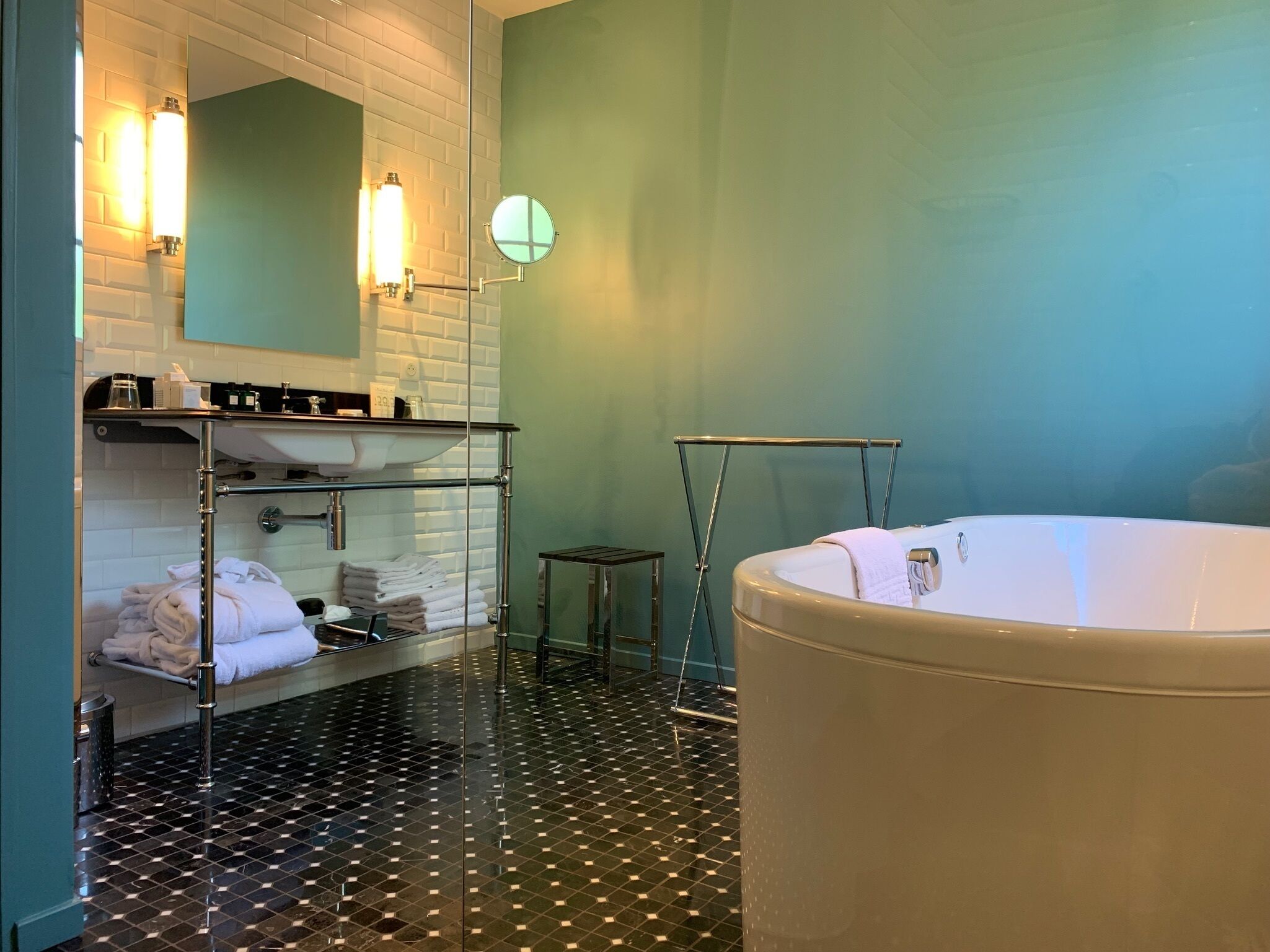 Een moderne badkamer met een groot bad, een douchecabine van glas en een witte wastafel met spiegel.